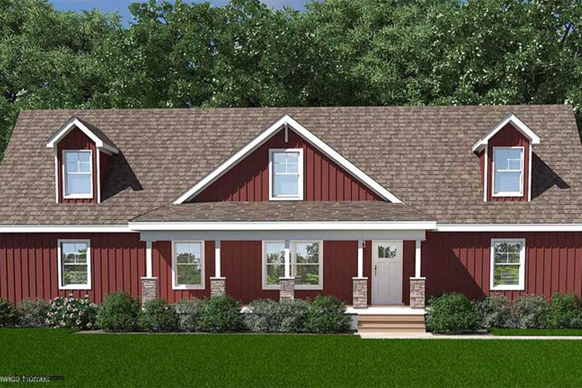 Red farmhouse with white trim, front porch, dormer windows, and green lawn in front of trees—a charming modular home blending classic style with modern convenience.